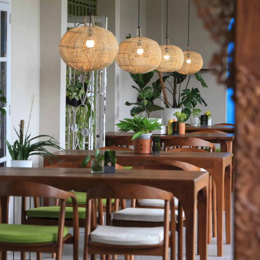 Ruang makan utama 5oUs Steakhouse dengan meja kayu dan lampu rotan gantung